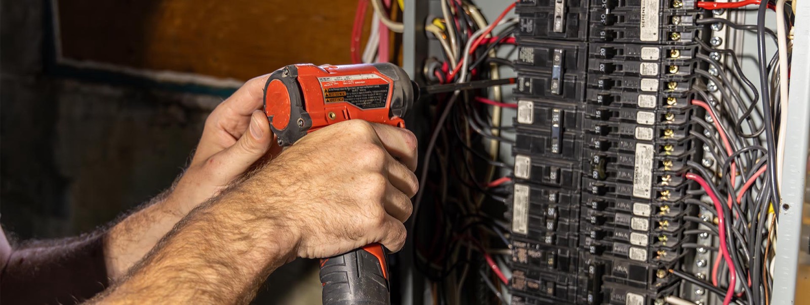 Electrician fastening breakers inside an electrical panel